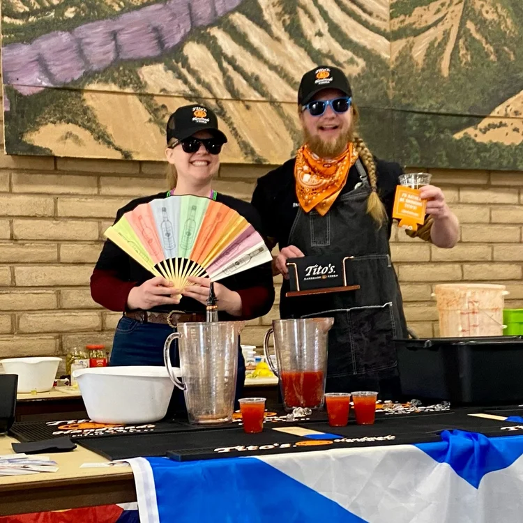 Jimmy and a teammate behind a Bloody Mary station draped in a Saltire flag