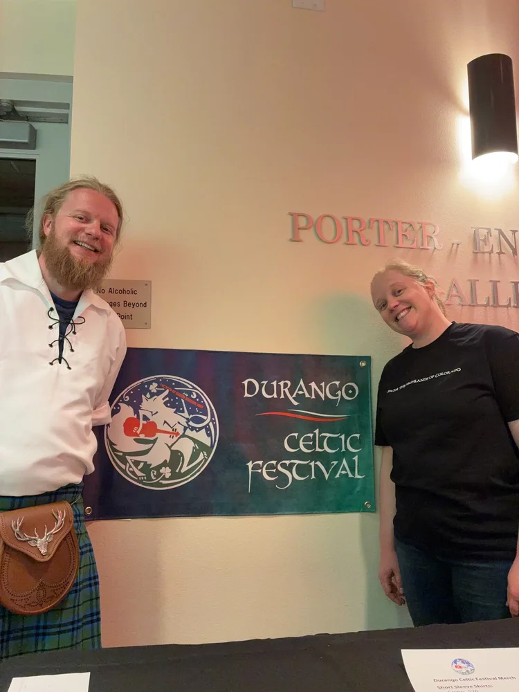 Jimmy in a kilt beside the Durango Celtic Festival banner